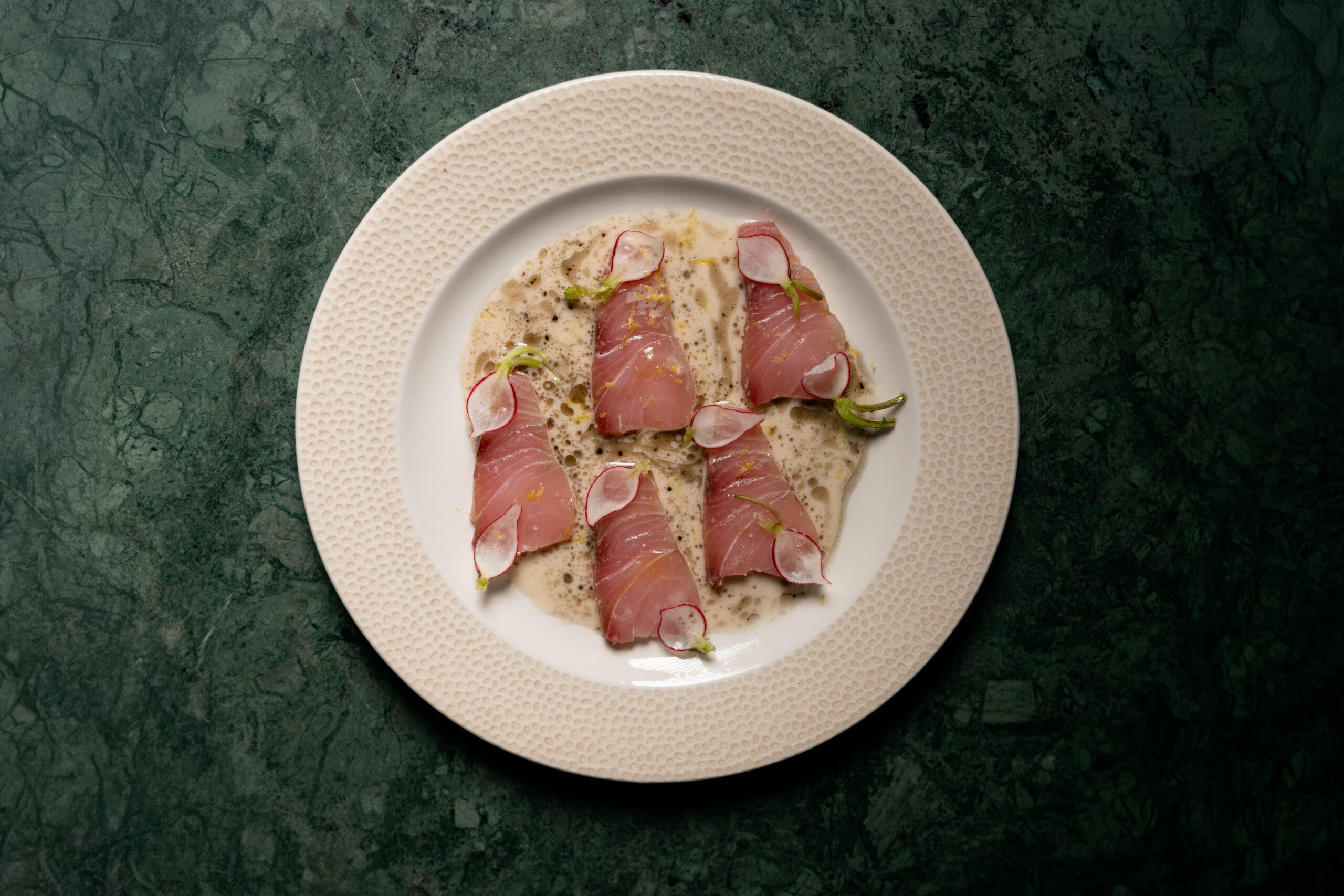 Crudo de peixe, leite de castanha-do-pará, óleo de kombu preto e rabanete