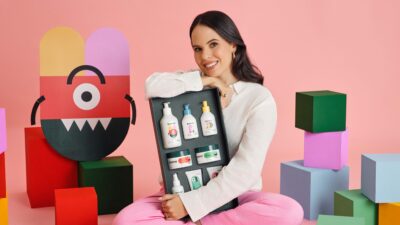 Marcela Castilho, fundadora da Booma, segurando os cosméticos de sua marca