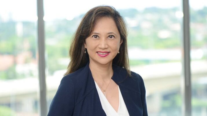 Jeane Tsutsui, CEO do Fleury (FLRY3) em um fundo de árvores e sorrindo