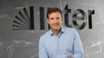 O vice-presidente e diretor financeiro (CFO) do Banco Inter, Santiago Stel, à frente de uma parede cinza com logo do banco.