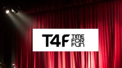 Fundo da imagem traz uma cortina vermelha iluminada, como a cortina de um teatro. Ao centro, o logo da T4F