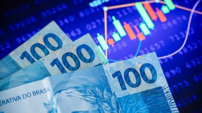 Gráfico de ações e notas de cem reais para representar a bolsa brasileira
