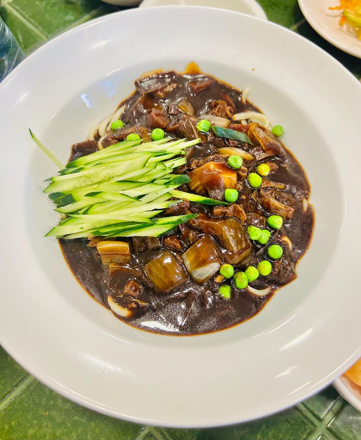 prato com Jajangmyeon, macarrão servido com molho de feijão-preto fermentado, carne e legumes.