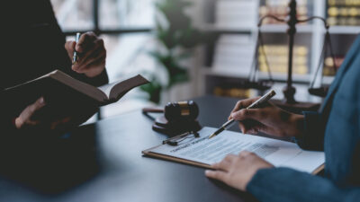 O departamento de execução jurídica marca uma reunião com o cliente para assinar um acordo de mediação para pagar a dívida. Advogado discute o documento do contrato. Tratado da lei. Assine um contrato comercial.