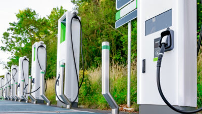 Uma estação de carregamento inovadora para veículos elétricos, situada em um ambiente verdejante, demonstra a tecnologia moderna necessária para um transporte ecológico.