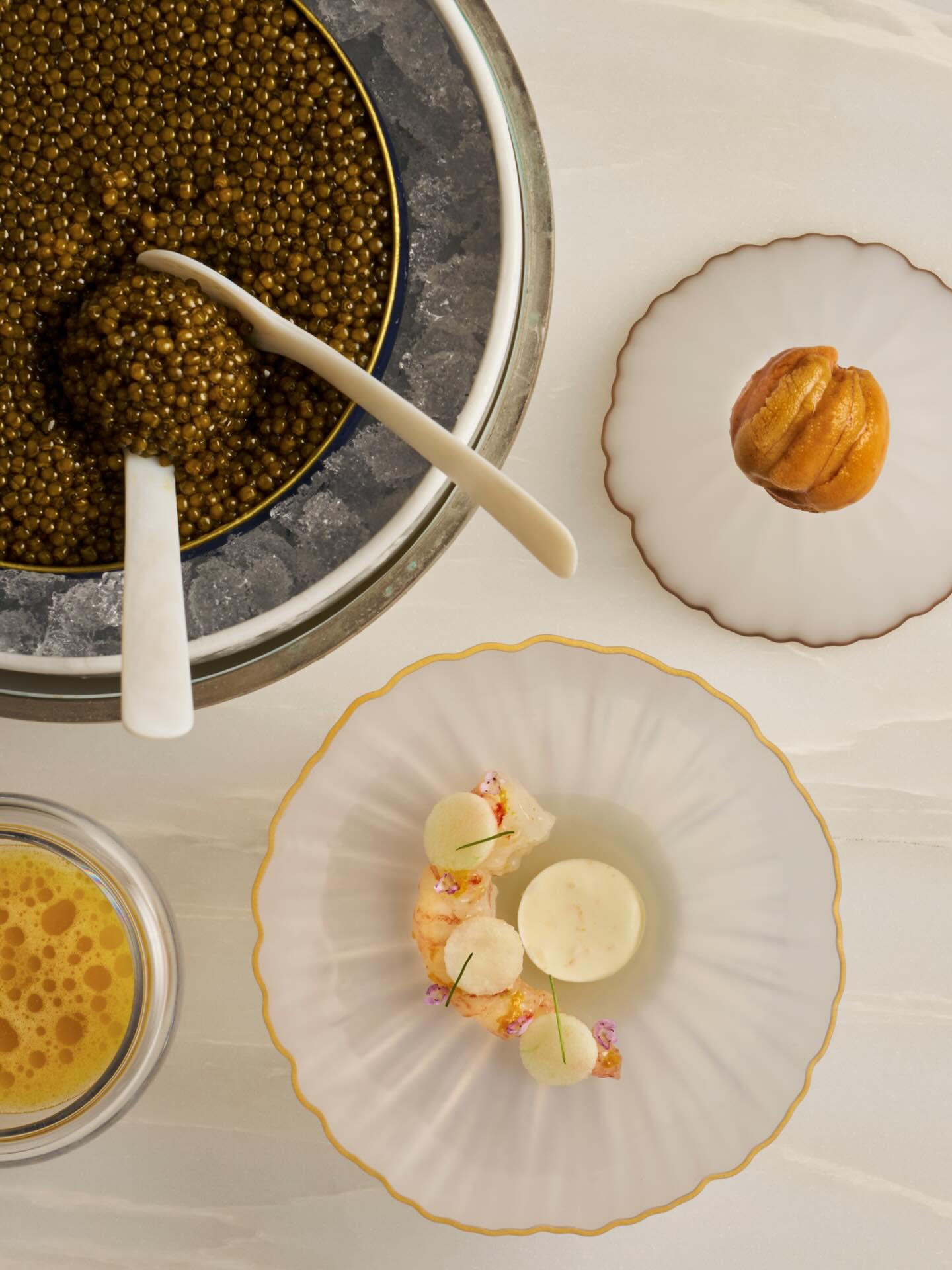 Seleção de entradas do Odette, de Cingapura: camarão-pintado glaceado com yuzu, ouriço sobre torrada e, ao topo, porção de caviar