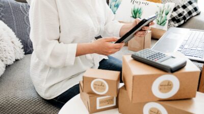 mulher empreendedora com caixas de produtos que serão enviados para os clientes