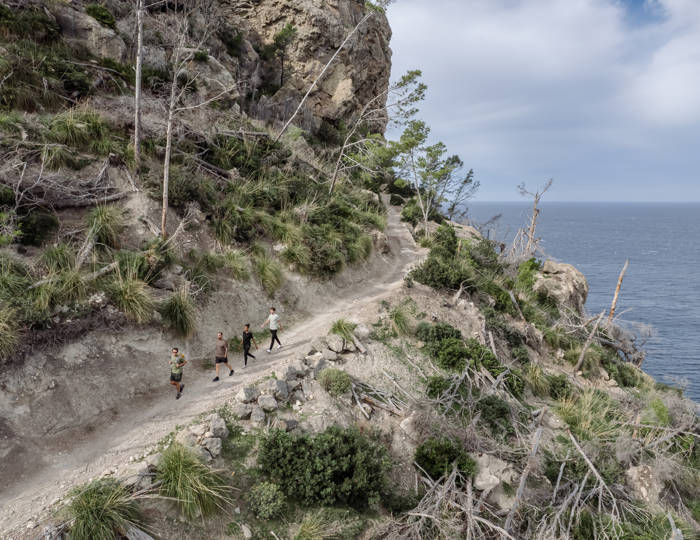 quatro pessoas caminhando um terreno de montanha