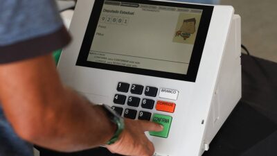 Imagem de um homem apertando as teclas da urna eletrônica