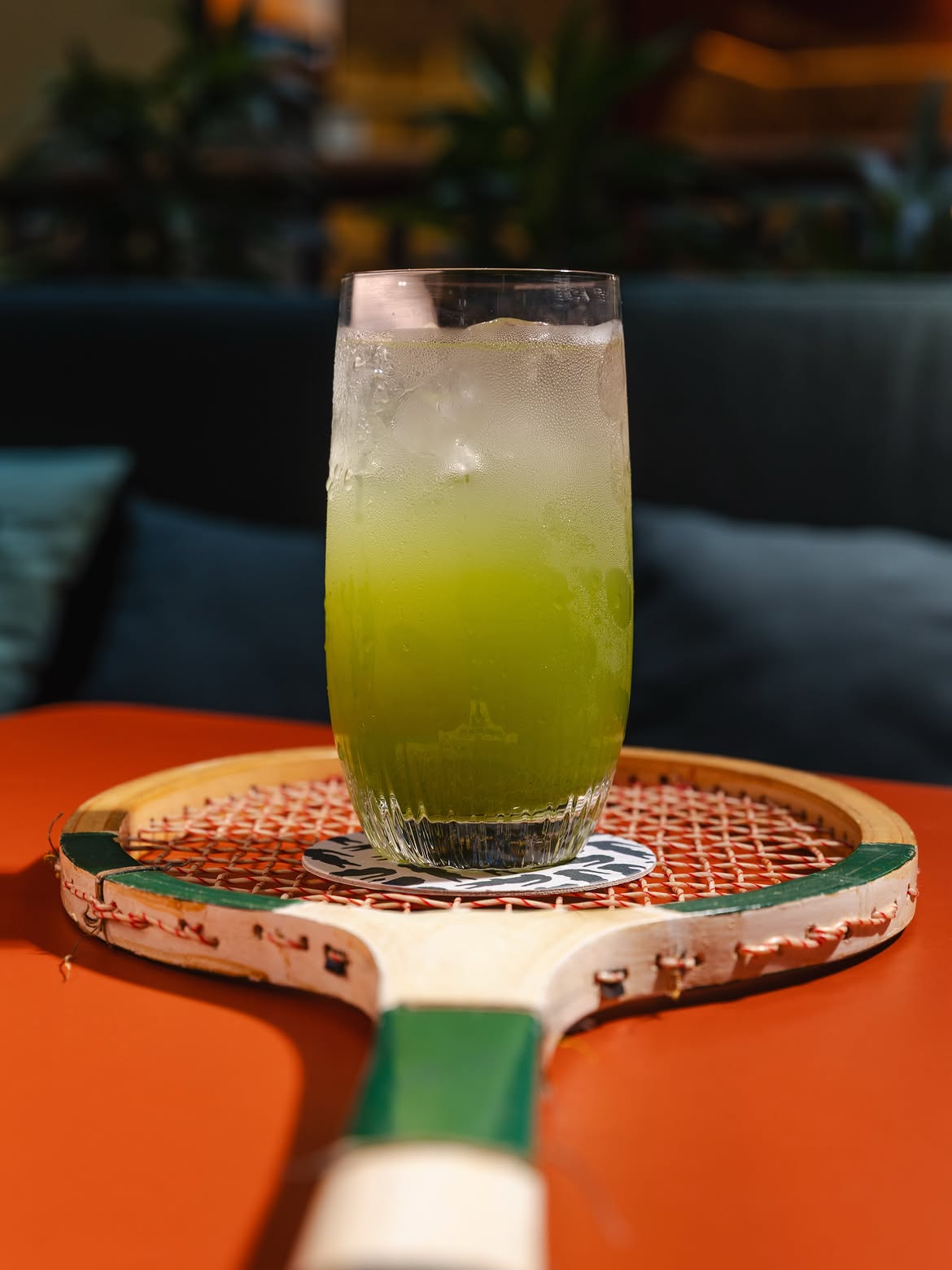 drink sobre raquete de tênis sobre mesa