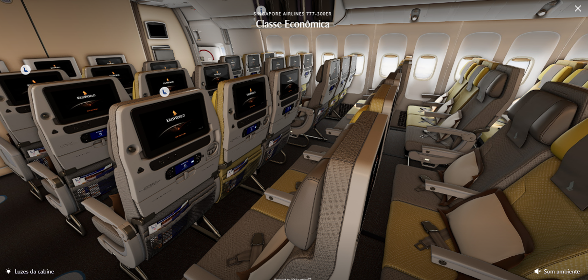 Interior da classe econômica da Singapore Airlines, com fileiras de assentos, apoios de cabeça e corredor central da aeronave.