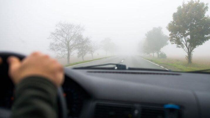 Motorista dirige em meio à neblina, com pouca visibilidade à frente