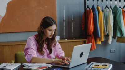 Profissional trabalhando em mesa com laptop em espaço de escritório de estúdio de moda