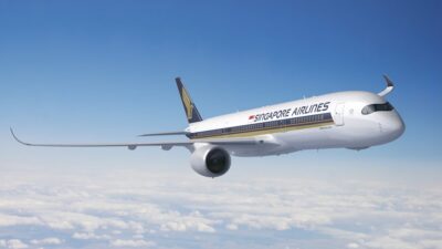 Avião da Singapore Airlines voando acima das nuvens sob céu azul.