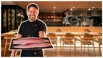 Chef Kazuo Harada sorridente em restaurante japonês segura uma bandeja com dois filés de peixe cru.