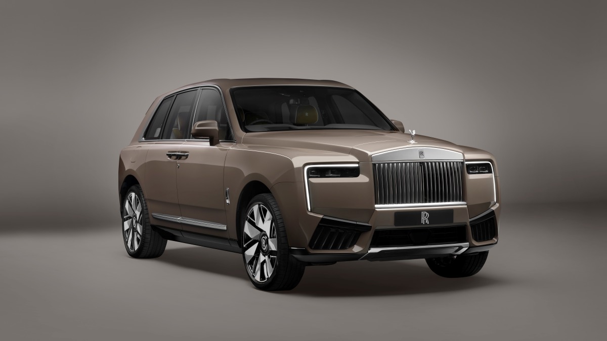 SUV marrom de luxo com grade cromada e logotipo Rolls-Royce em estúdio.