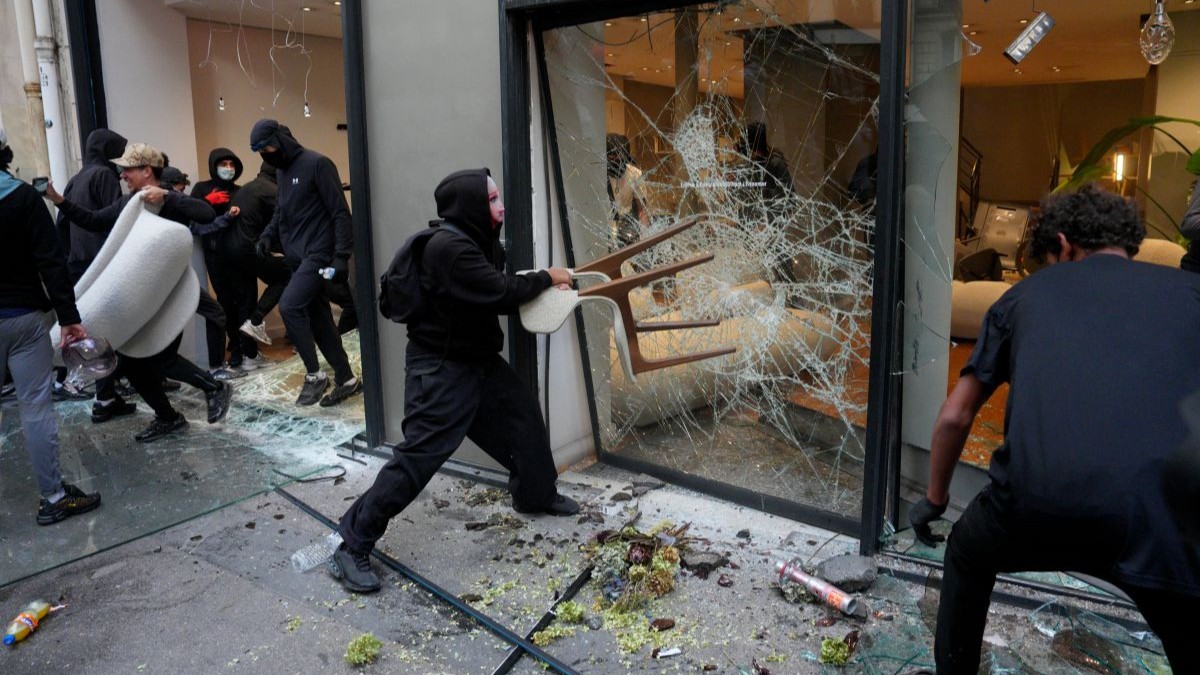 Manifestantes vandalizam uma loja durante um protesto próximo à Place de la République, enquanto o movimento dos "Coletes Amarelos" (Gilets Jaunes) se une a estudantes para um fim de semana de mobilização, em 17 de outubro de 2026, em Paris, França.